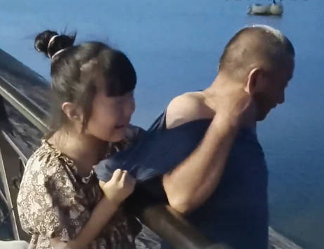 爺爺想下河撈玩具被孫女緊緊拉住 孫女擔心地大哭緊拽爺爺衣服阻止
